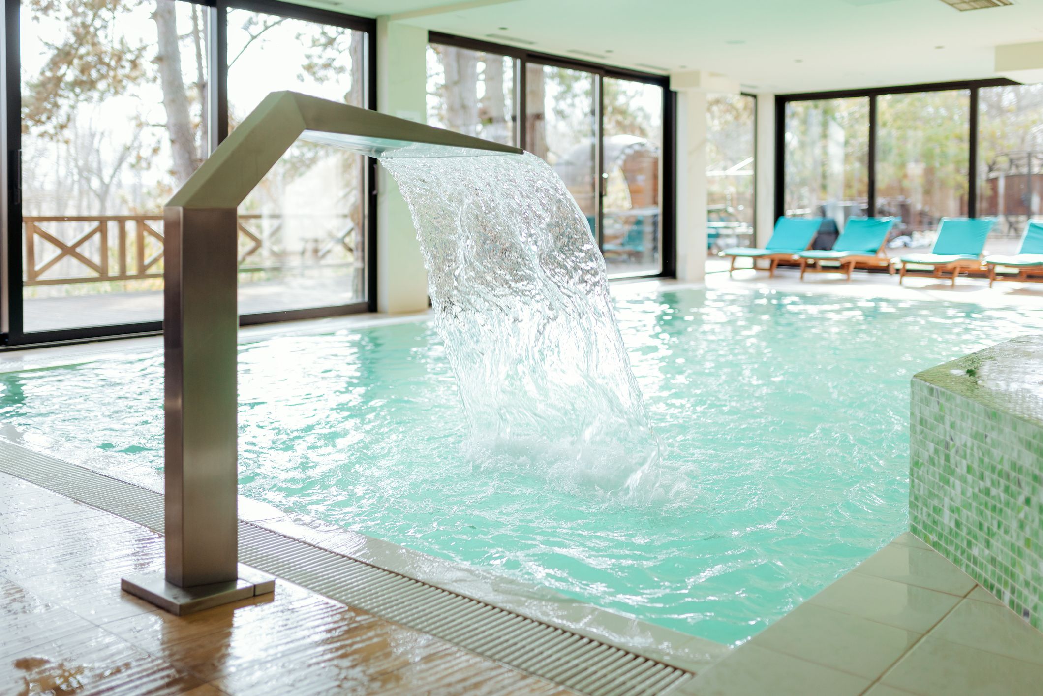 Indoor pool with water fountain feature.